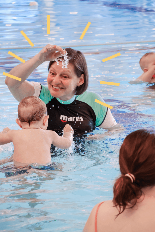 Tijdens babyzwemmen speelt een baby met de docent in het water